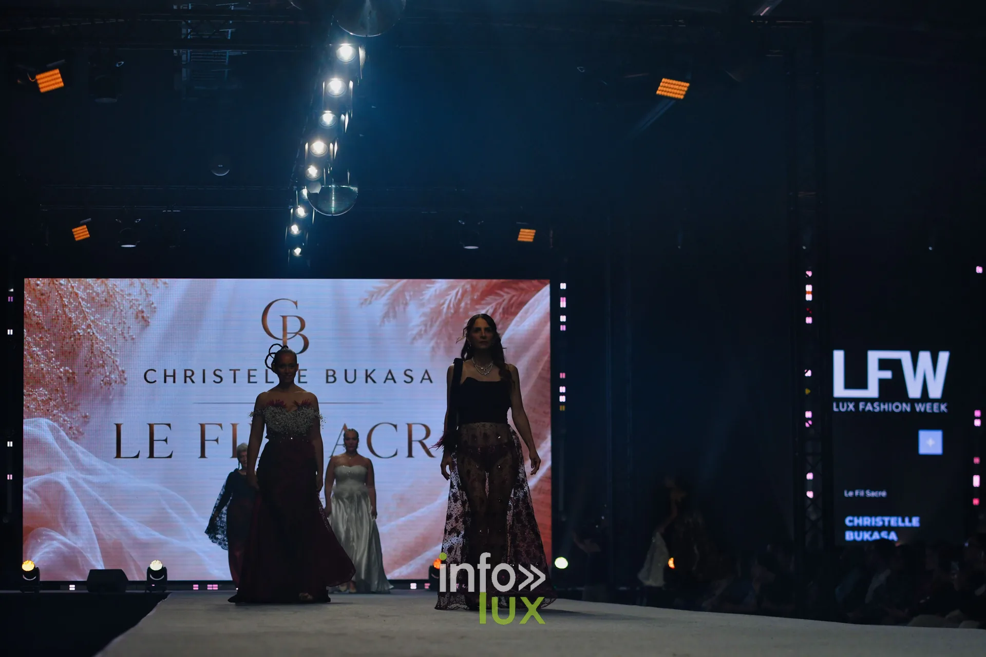 Vue du podium : l’écran affiche le monogramme « CB », le nom de Christelle Bukasa et le titre « Le Fil Sacré », Lux Fashion Week 2026, Arlon