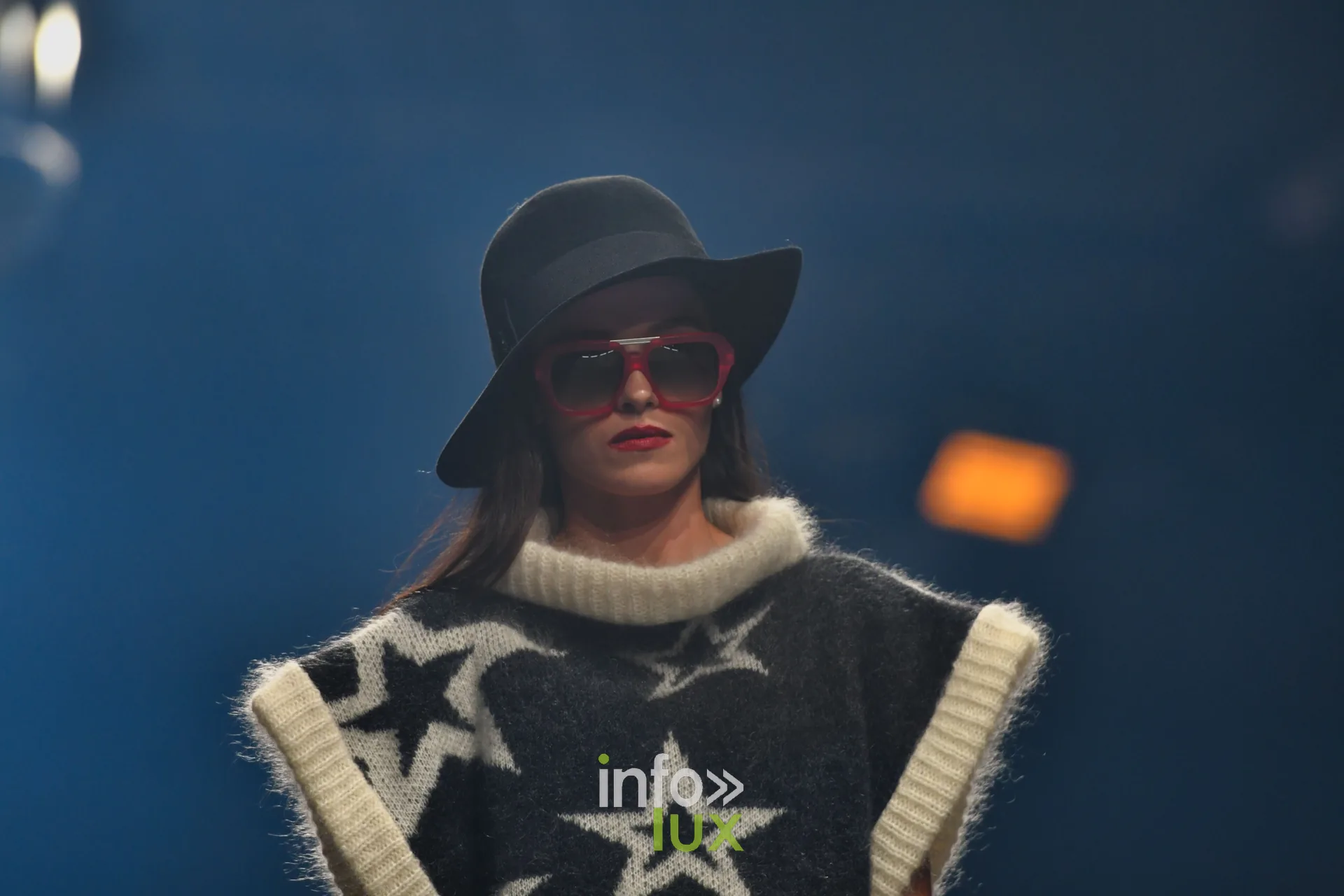Pull sans manches noir à grandes étoiles blanches, col roulé écru, chapeau noir — Damlaws, « The Dam Star », Lux Fashion Week 2026, Arlon