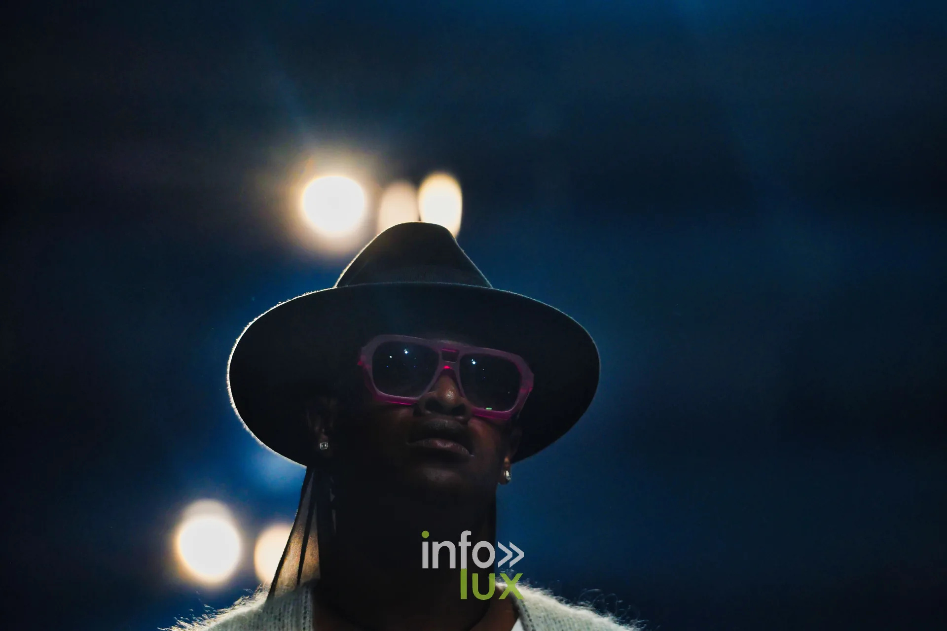 Chapeau noir à larges bords et lunettes roses, à contre-jour — Damlaws, « The Dam Star », Lux Fashion Week 2026, Arlon