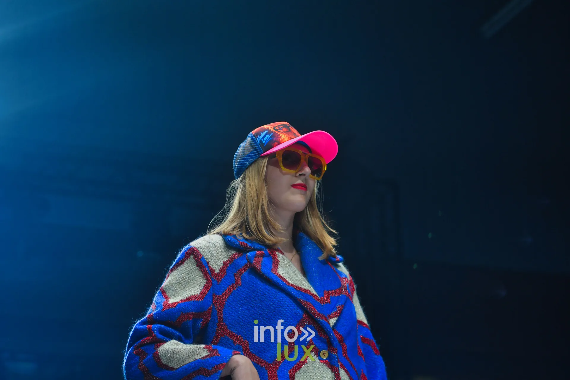 Manteau en maille bleu roi et écru à motifs rouges, casquette rose et bleue — Damlaws, « The Dam Star », Lux Fashion Week 2026, Arlon