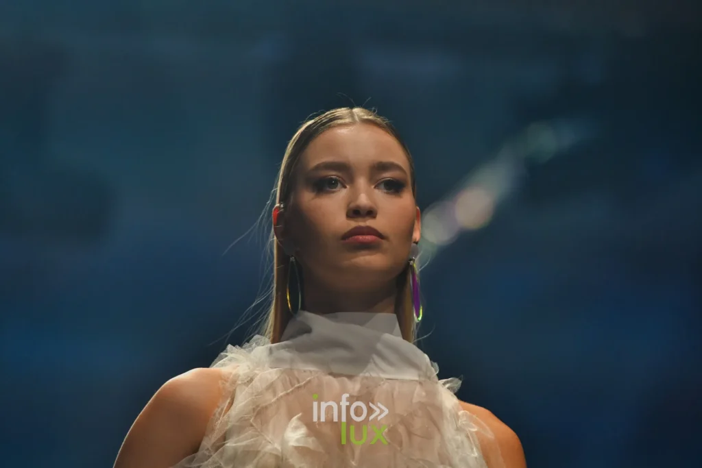 Portrait : haut en tulle à volants, col montant, créoles dorées — Francini_K, « La géométrie des fleurs », Lux Fashion Week 2026, Arlon