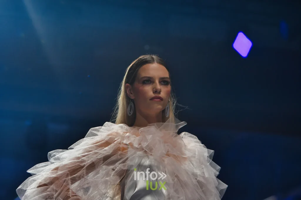 Cape de tulle à volants sur une robe de satin blanc — Francini_K, « La géométrie des fleurs », Lux Fashion Week 2026, Arlon