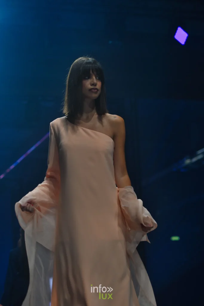 Robe longue couleur pêche à une épaule, drapé transparent sur le bras — Francini_K, « La géométrie des fleurs », Lux Fashion Week 2026, Arlon