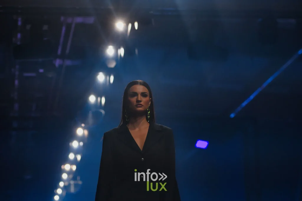 Veste de tailleur noire croisée, longues boucles d’oreilles — Francini_K, « La géométrie des fleurs », Lux Fashion Week 2026, Arlon