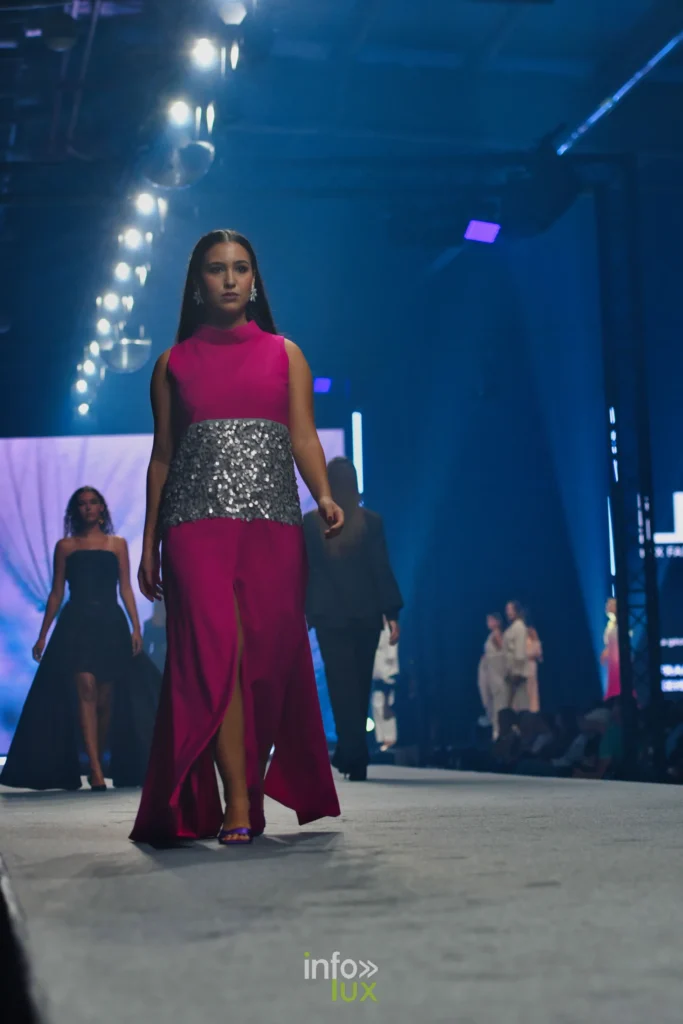 Robe longue fuchsia sans manches, fendue, large bande de sequins argentés à la taille — Francini_K, « La géométrie des fleurs », Lux Fashion Week 2026, Arlon
