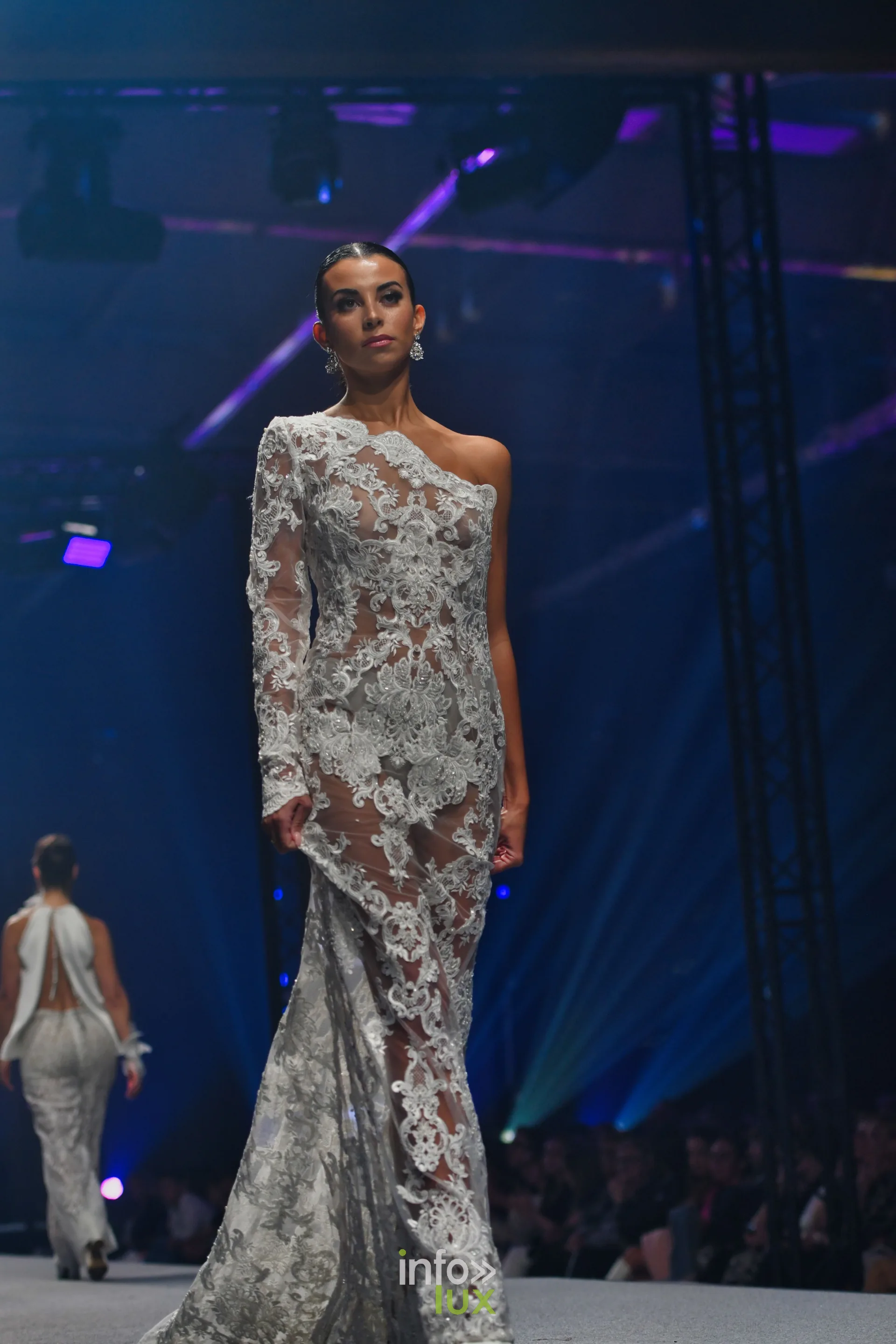 Robe longue en dentelle blanche à une épaule, en pied, collection « Meraki bloom » d’Hélène Guiot, Lux Fashion Week 2026, Arlon
