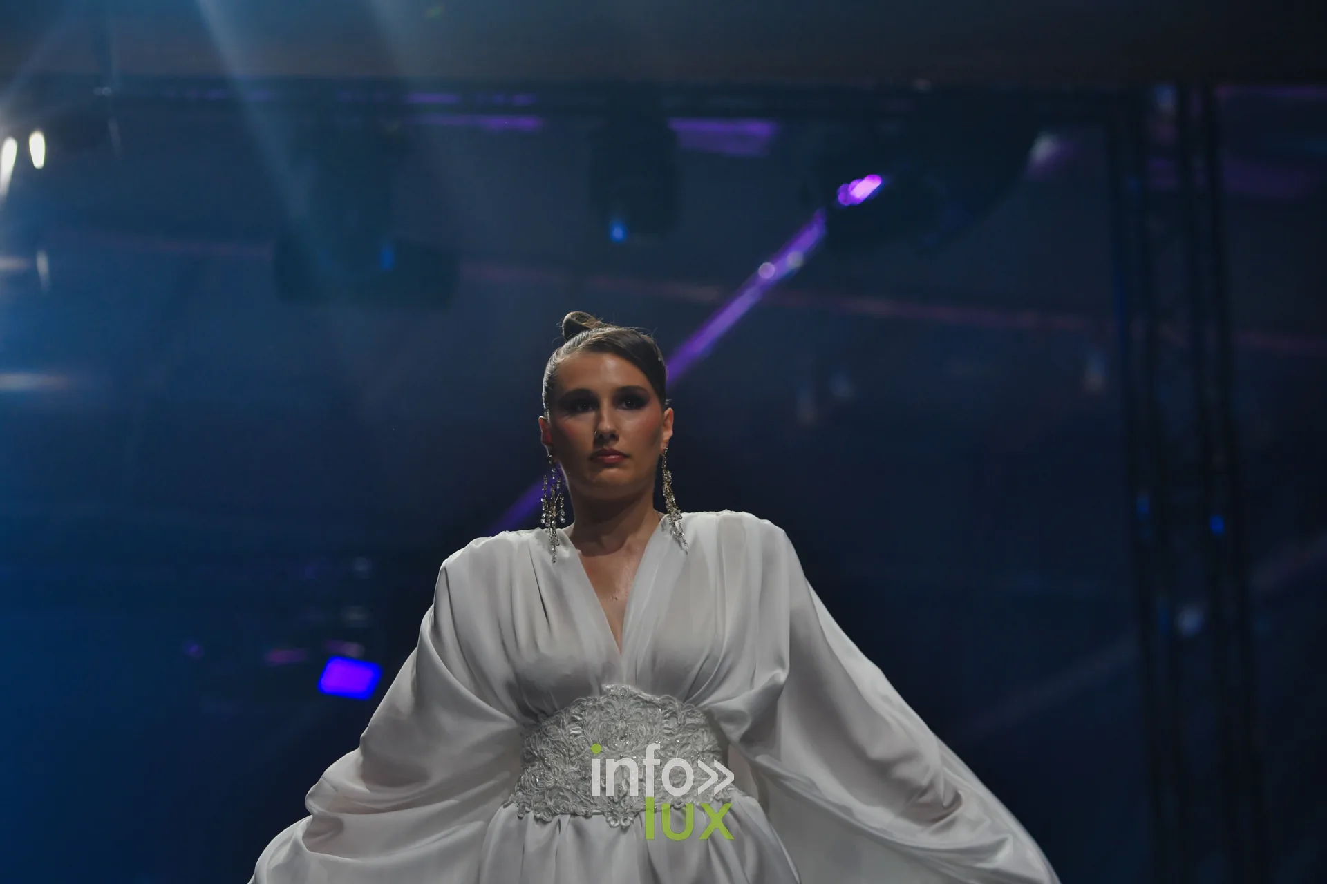 Robe blanche satinée à manches amples et ceinture de dentelle, collection « Meraki bloom » d’Hélène Guiot, Lux Fashion Week 2026, Arlon
