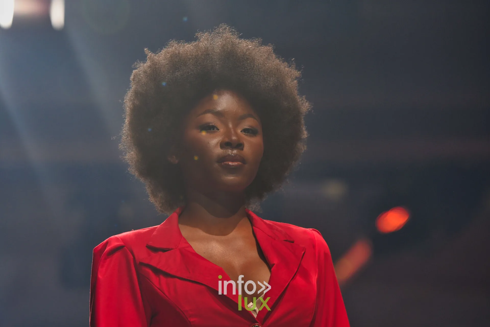 Veste-chemise rouge à revers, coiffure afro — R. Lopes, « Raízes d’Ouro », Lux Fashion Week 2026, Arlon