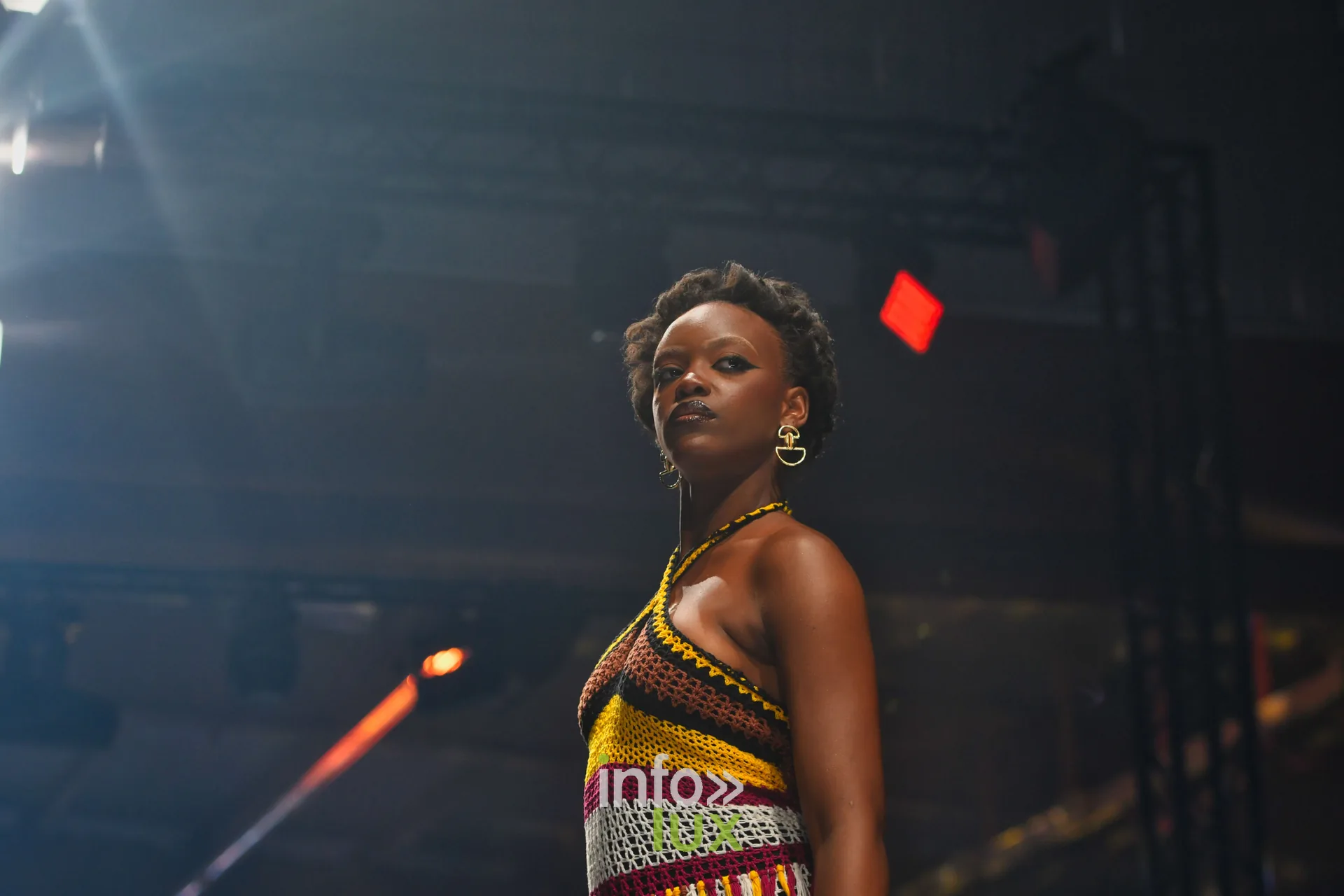 Haut dos nu en crochet jaune, rouge, noir et blanc, collier doré — R. Lopes, « Raízes d’Ouro », Lux Fashion Week 2026, Arlon