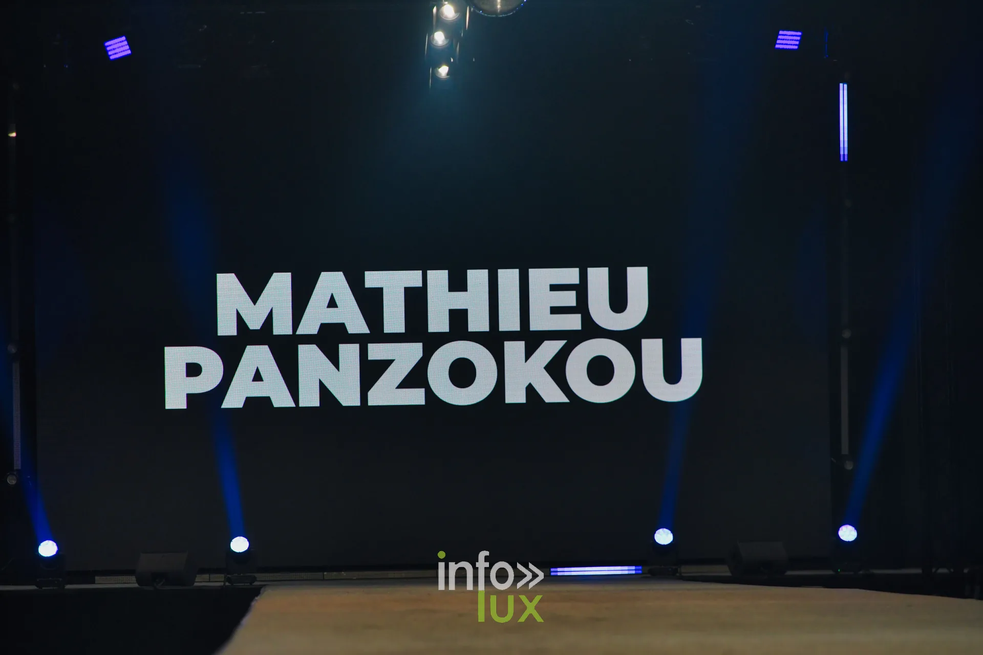 Écran de scène au nom de Mathieu Panzokou, au début de son passage, Lux Fashion Week 2026, Arlon