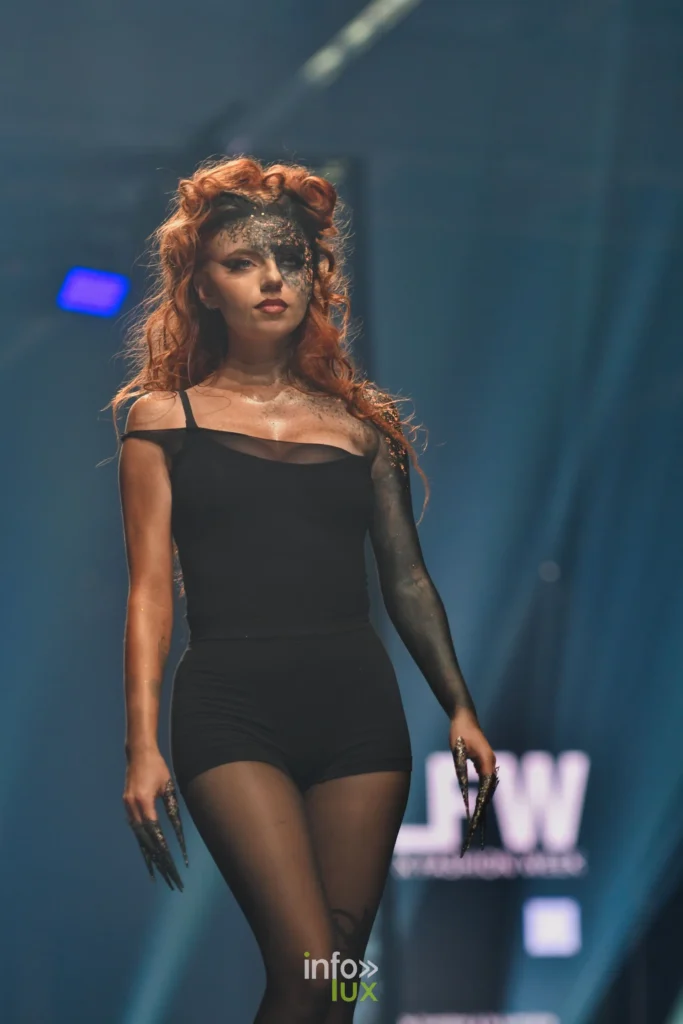 Mannequin rousse en noir, collants et longs ongles argentés, sur le podium, Lux Fashion Week 2026, Arlon