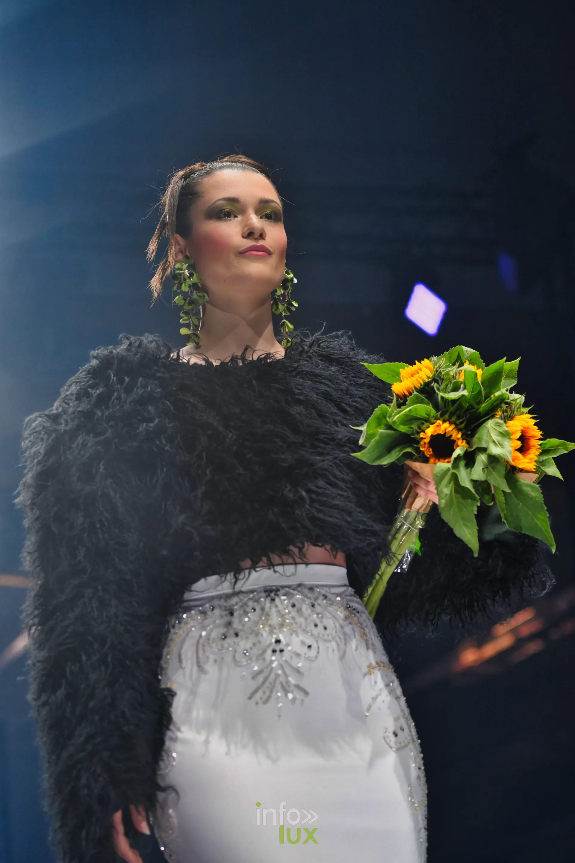 Veste courte noire à poils longs, jupe blanche brodée et bouquet de tournesols, collection « Bridal Everyday » de Marie Schweisthal, Lux Fashion Week 2026, Arlon
