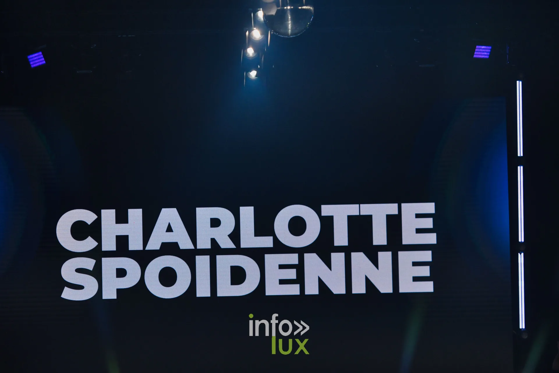 L’écran de scène affiche « CHARLOTTE SPOIDENNE » juste avant le passage — Charlotte Spoidenne, « Diffraction », Lux Fashion Week 2026, Arlon