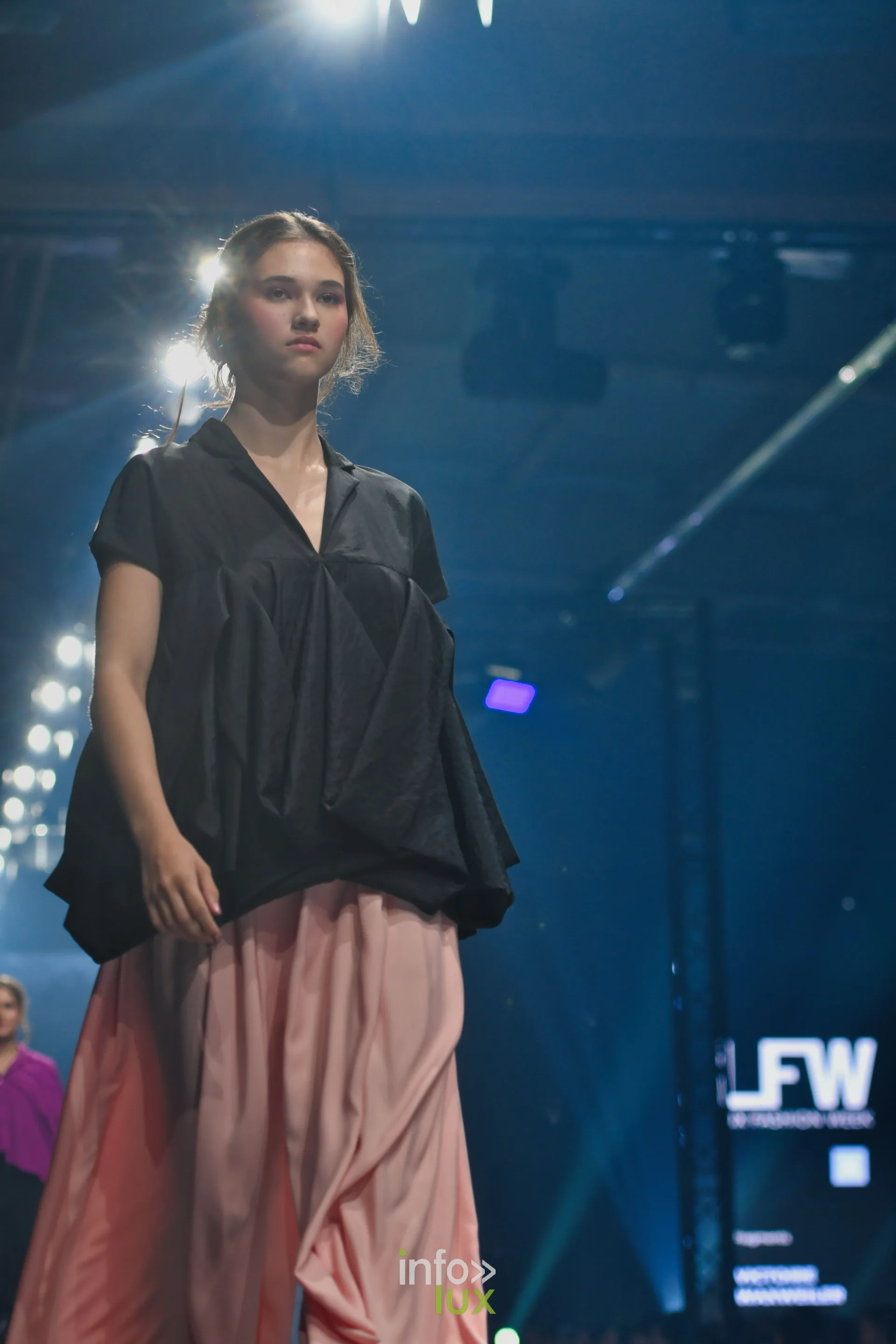 Blouse noire ample à manches courtes sur jupe longue rose saumon — Victoire Waxweiler, « Fragments », Lux Fashion Week 2026, Arlon