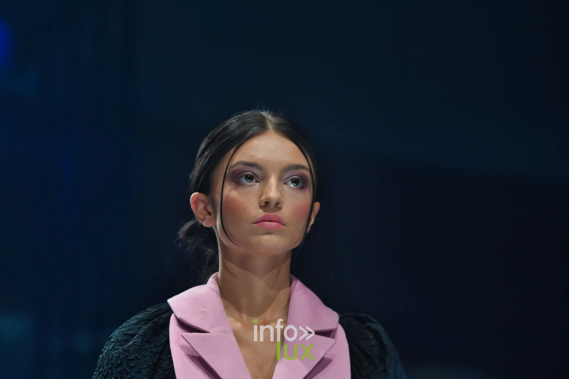 Gilet rose à revers sur manteau noir texturé, en gros plan — Victoire Waxweiler, « Fragments », Lux Fashion Week 2026, Arlon