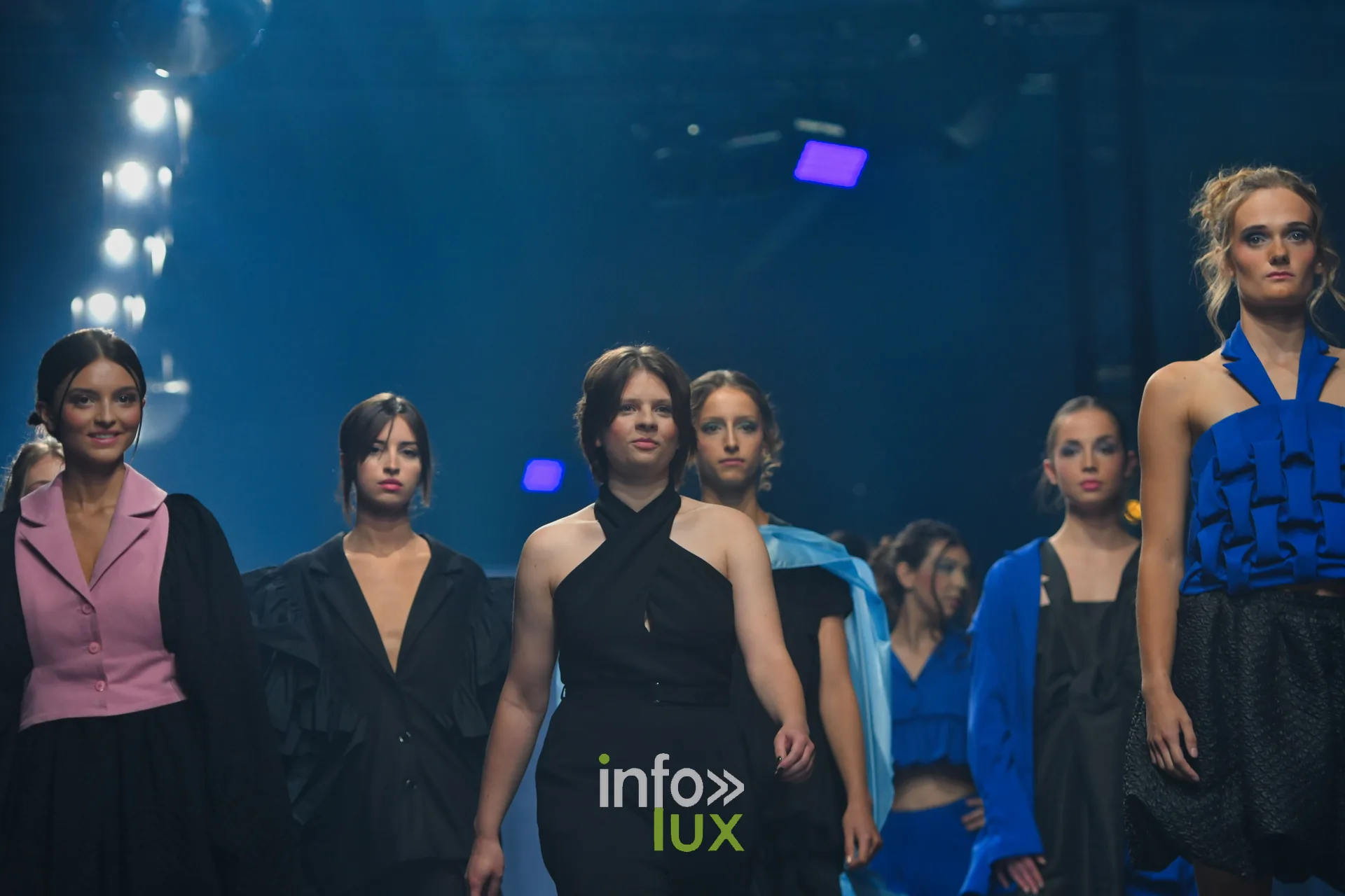 Final : les mannequins avancent ensemble, gilet rose, veste noire, haut croisé noir et haut bleu roi à volants — Victoire Waxweiler, « Fragments », Lux Fashion Week 2026, Arlon