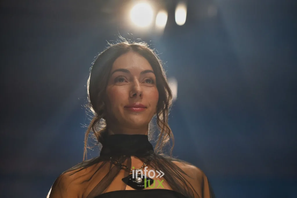 Portrait : ras-du-cou noir à pendentif et blouse transparente — Tania Zorina, « Élégance Florale », Lux Fashion Week 2026, Arlon