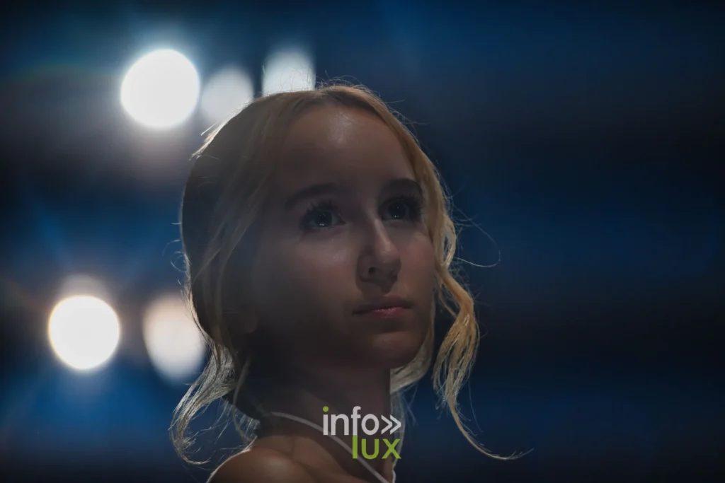 Portrait de trois quarts sous les projecteurs — Tania Zorina, « Élégance Florale », Lux Fashion Week 2026, Arlon