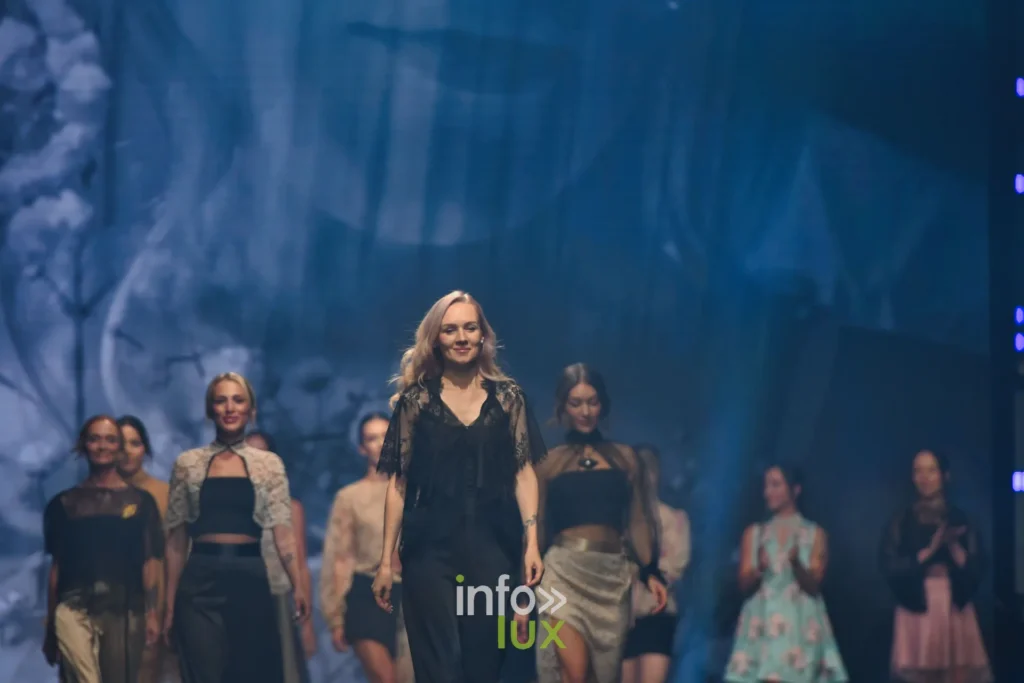 Retour des silhouettes sur le podium devant un écran aux fleurs blanches — Tania Zorina, « Élégance Florale », Lux Fashion Week 2026, Arlon