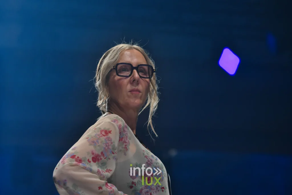 Portrait : blouse transparente à fleurs roses et lunettes noires — Tania Zorina, « Élégance Florale », Lux Fashion Week 2026, Arlon