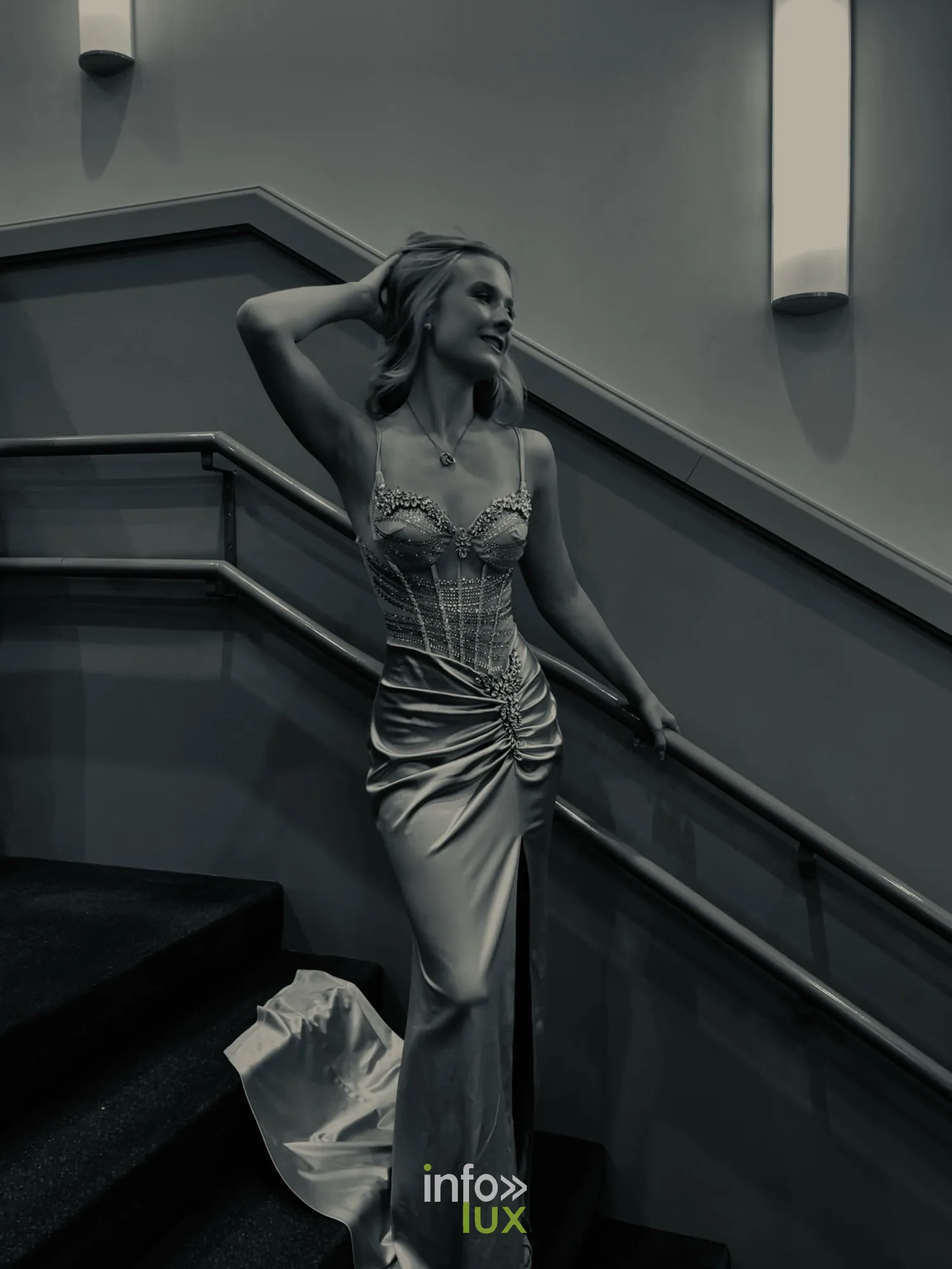 Portrait noir et blanc de Mackenzie en robe de soirée dans un escalier