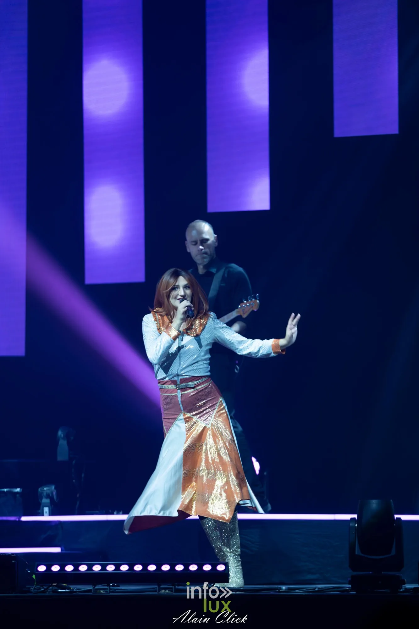 La chanteuse en jupe cuivrée seule au micro sous une lumière violette, Mania The ABBA Tribute, Zénith de Nancy, 25 septembre 2026