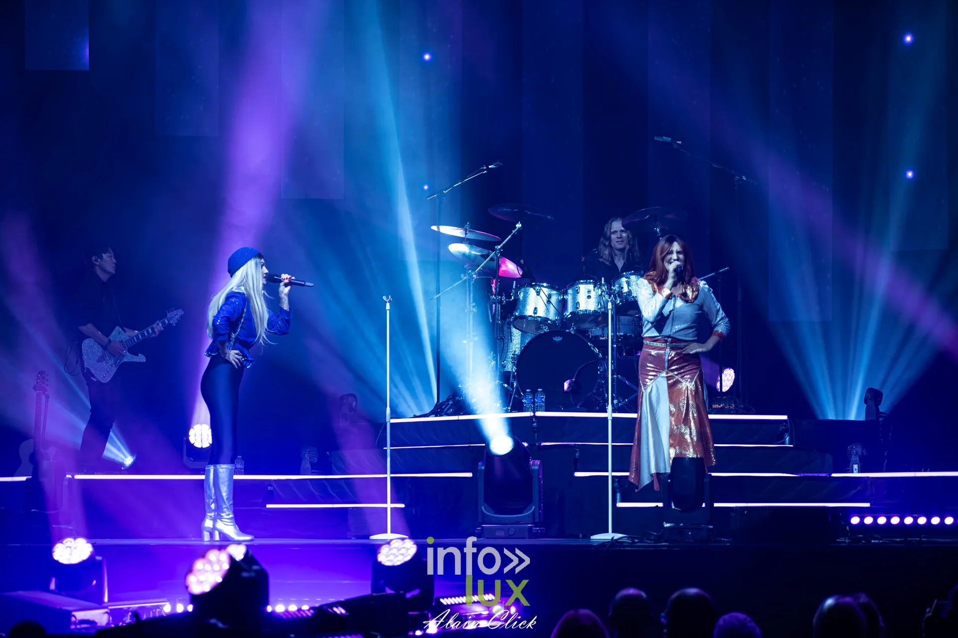 Les deux chanteuses au micro entre les faisceaux bleus, Mania The ABBA Tribute, Zénith de Nancy, 25 septembre 2026