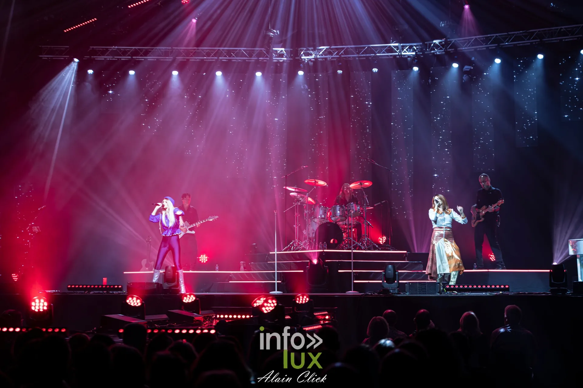 Vue d’ensemble de la scène sous une lumière rouge et des faisceaux blancs, Mania The ABBA Tribute, Zénith de Nancy, 25 septembre 2026