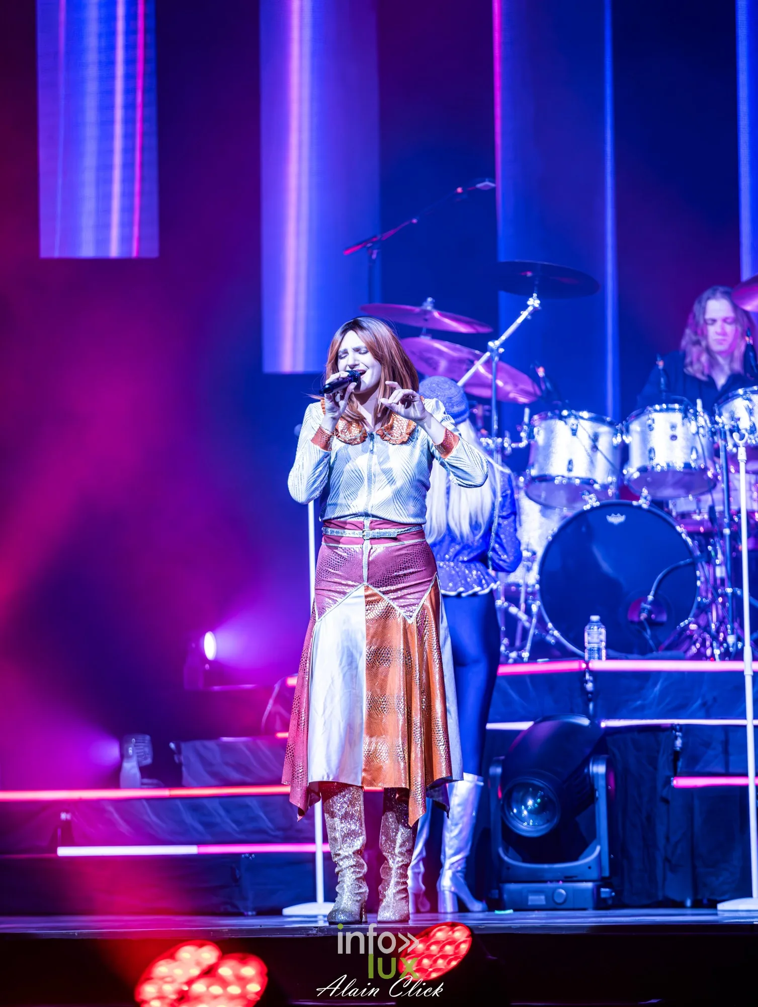 La chanteuse en jupe cuivrée au micro devant la batterie, Mania The ABBA Tribute, Zénith de Nancy, 25 septembre 2026