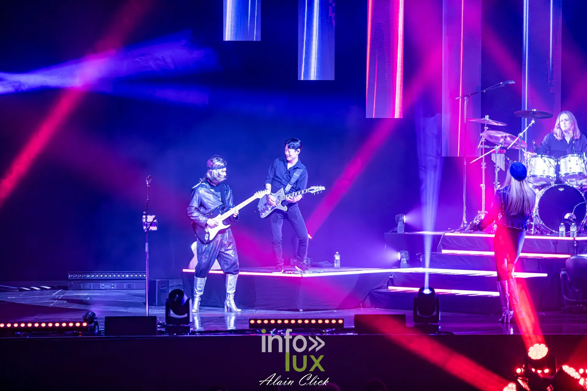 Deux guitaristes au premier plan sous des faisceaux roses, Mania The ABBA Tribute, Zénith de Nancy, 25 septembre 2026