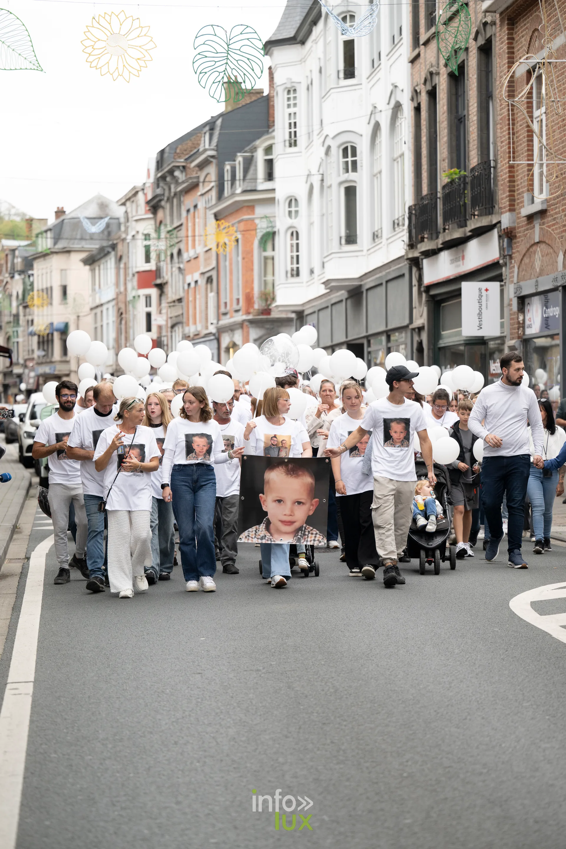 Le cortège de la marche blanche remonte une rue commerçante de Dinant