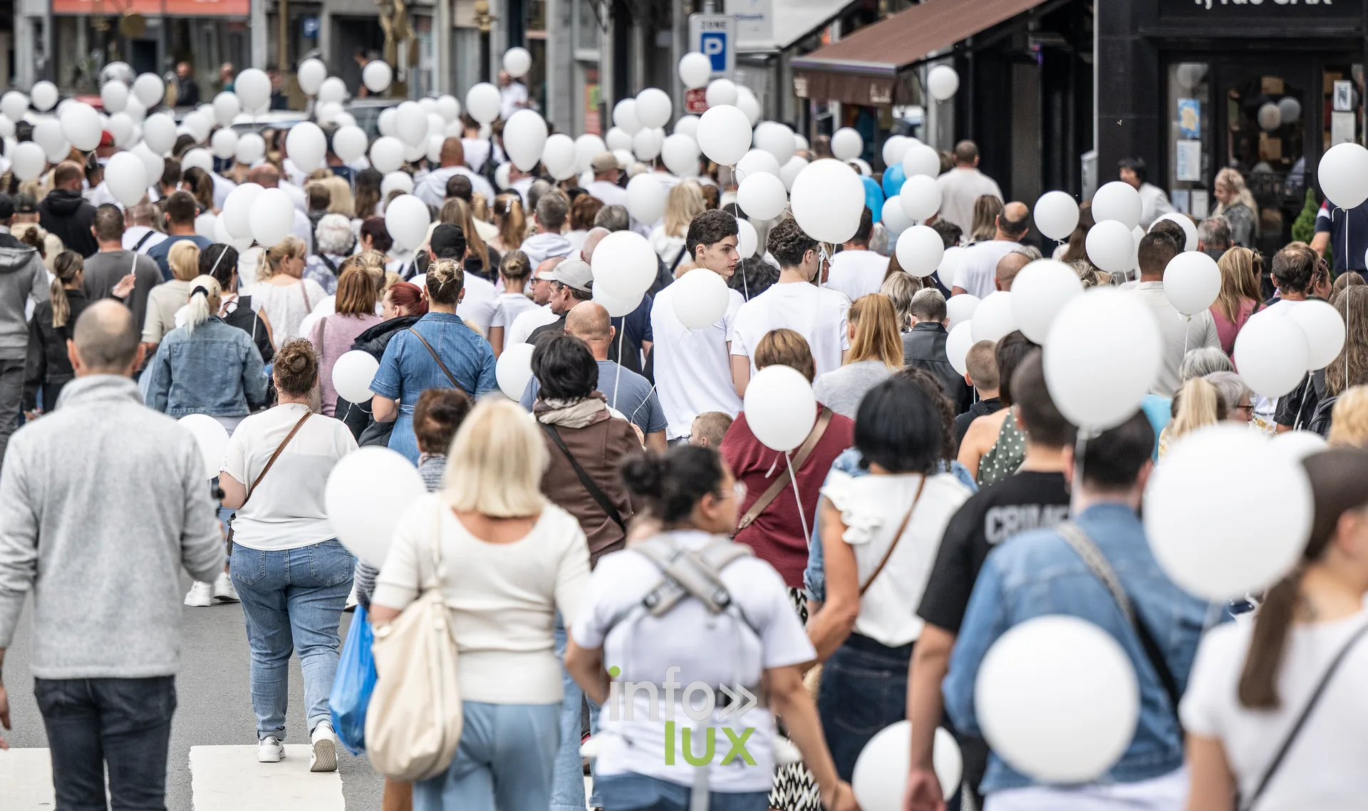 Vue de dos sur la foule et la forêt de ballons blancs de la marche