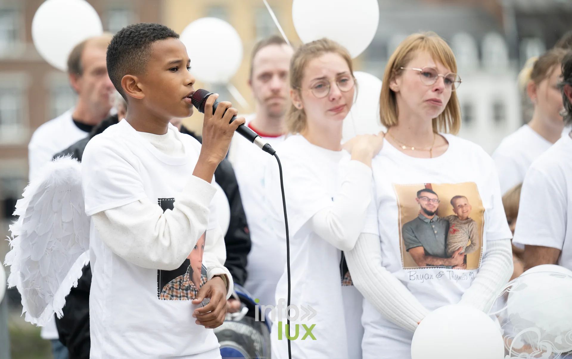 Roméo, vêtu d'ailes d'ange, chante au micro lors de la marche blanche