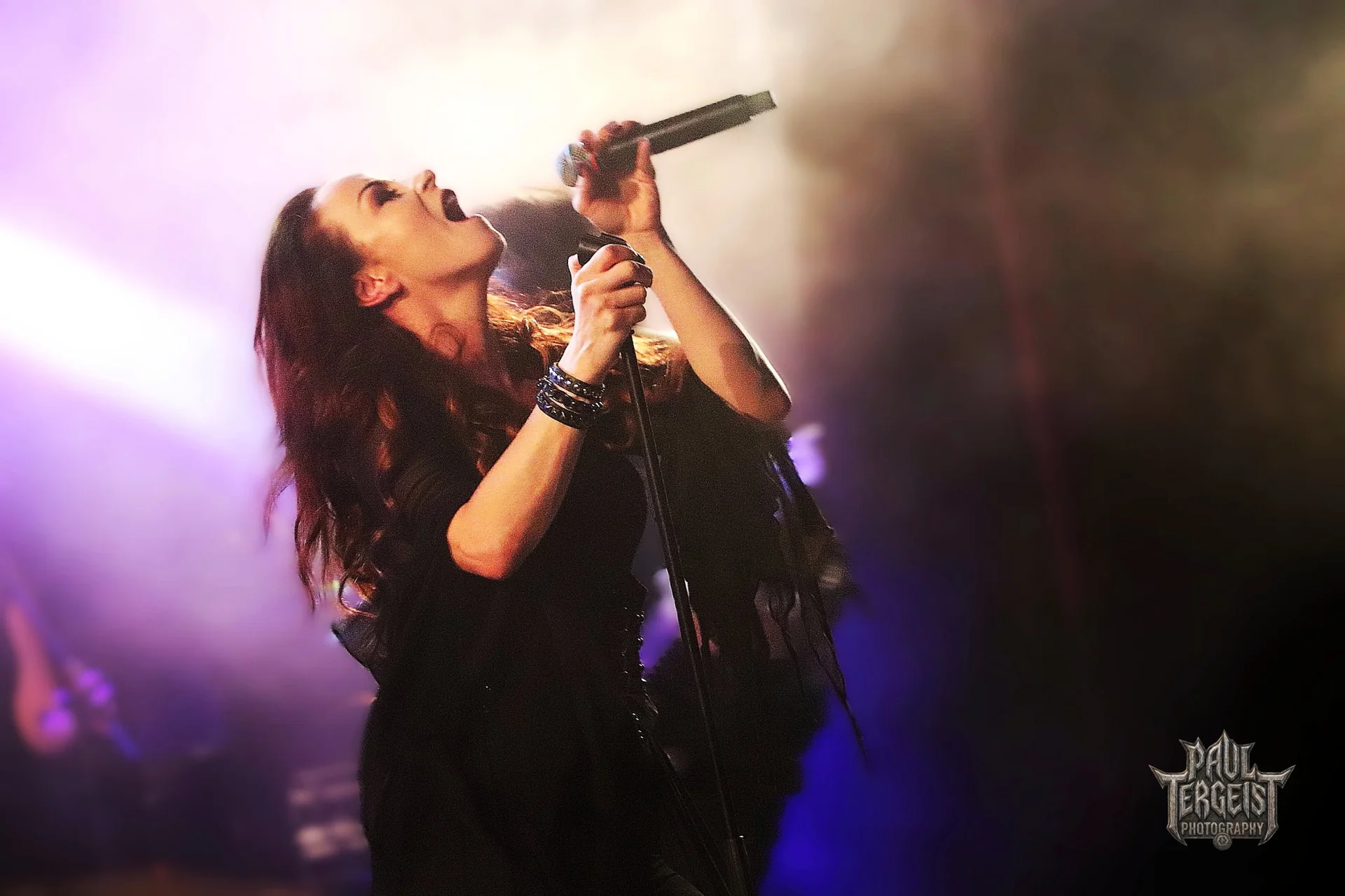 Maria Catharina chante au micro sous une lumiere violette au Golden Age Rock Festival