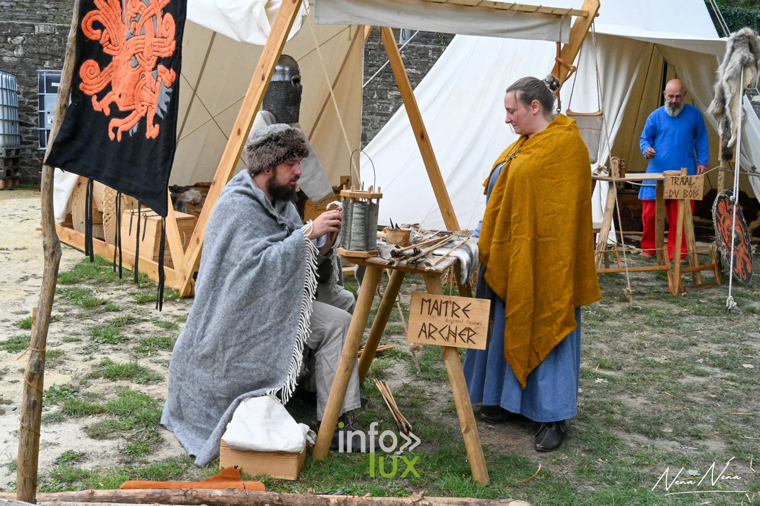Un campement avec l’enseigne d’un maître archer et des personnages en costume