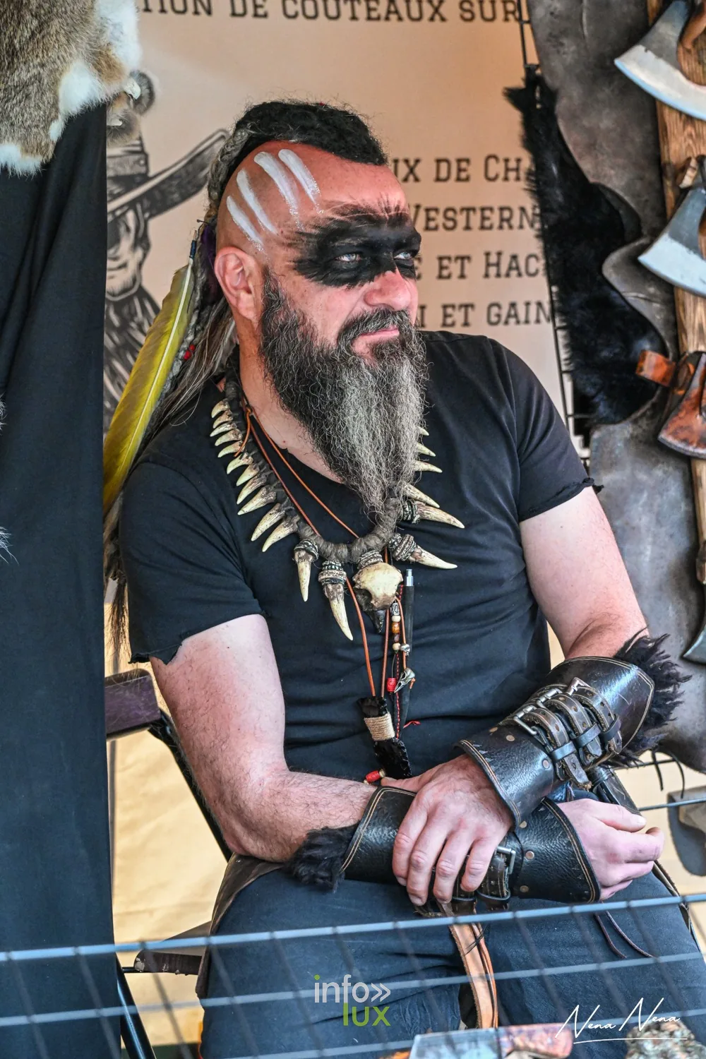 Portrait d’un artisan au visage peint, collier de dents et brassards de cuir