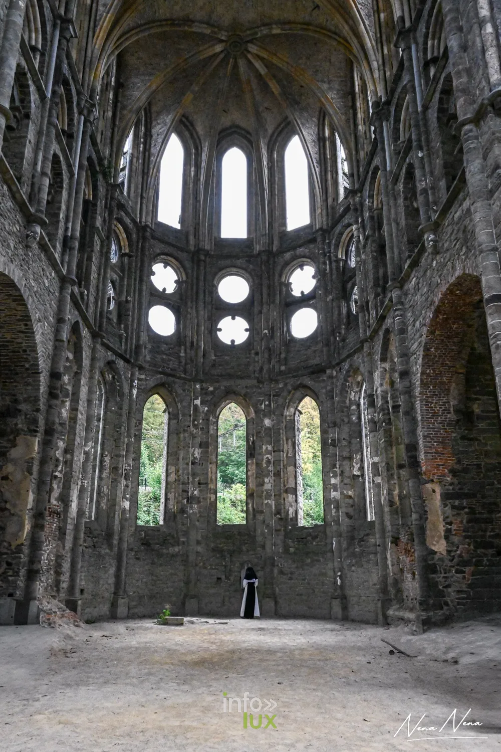 Le chœur en ruine de l’abbatiale de Villers avec ses hautes fenêtres, une silhouette au centre