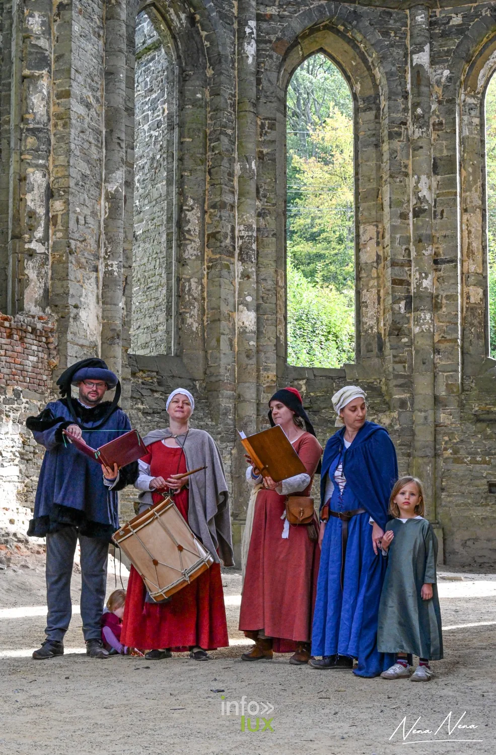 Une famille de musiciens en costume médiéval, tambour et livres, dans l’abbatiale