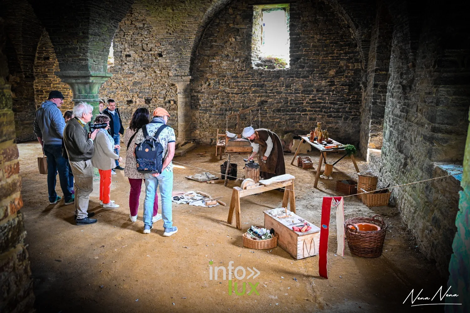Des visiteurs découvrent un atelier reconstitué dans une salle voûtée de l’abbaye