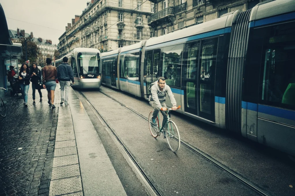 Cycliste roulant le long de trams dans une rue de ville europeenne