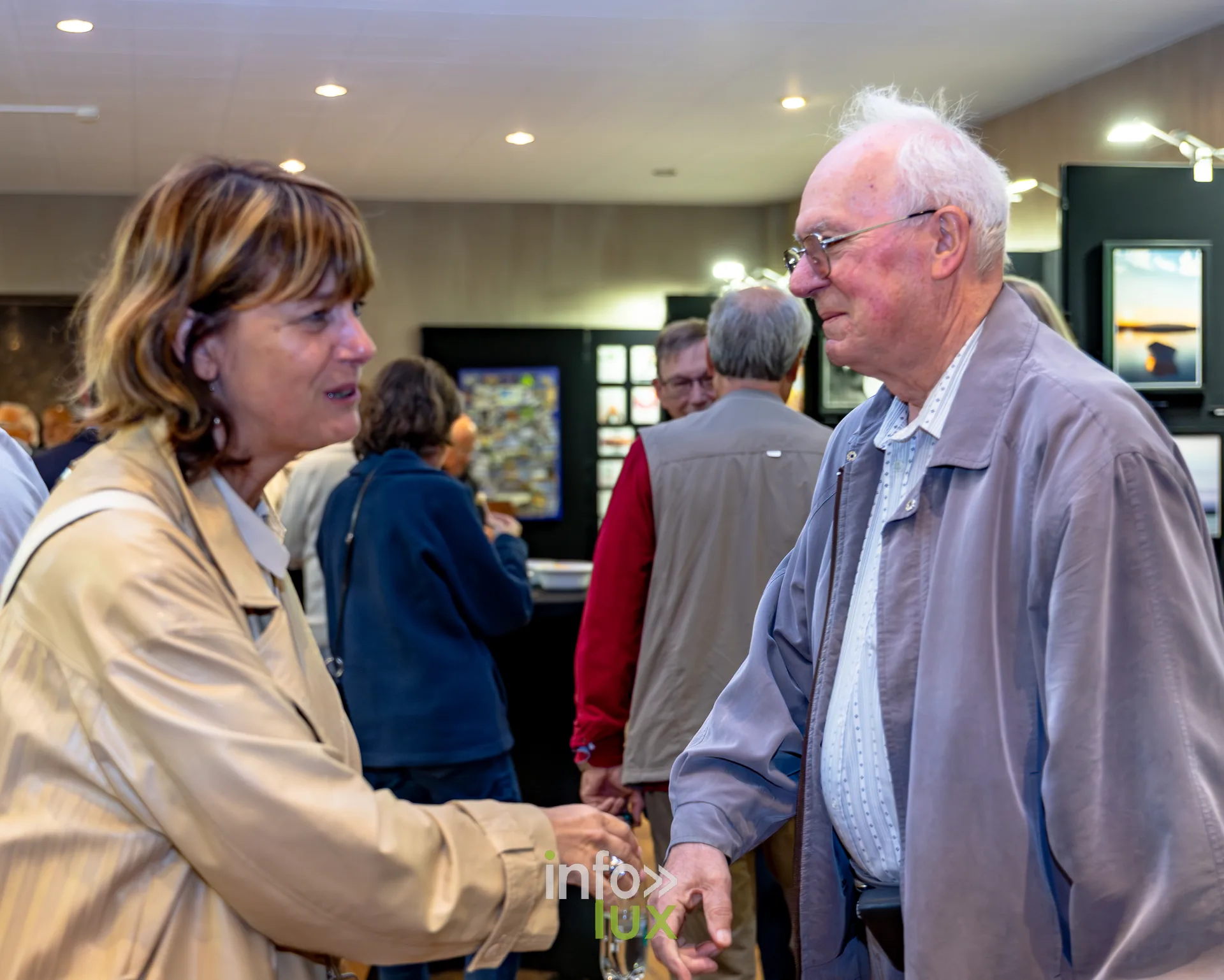 Deux visiteurs en conversation devant les photographies exposées au vernissage du Royal Photo Club Entre Nous