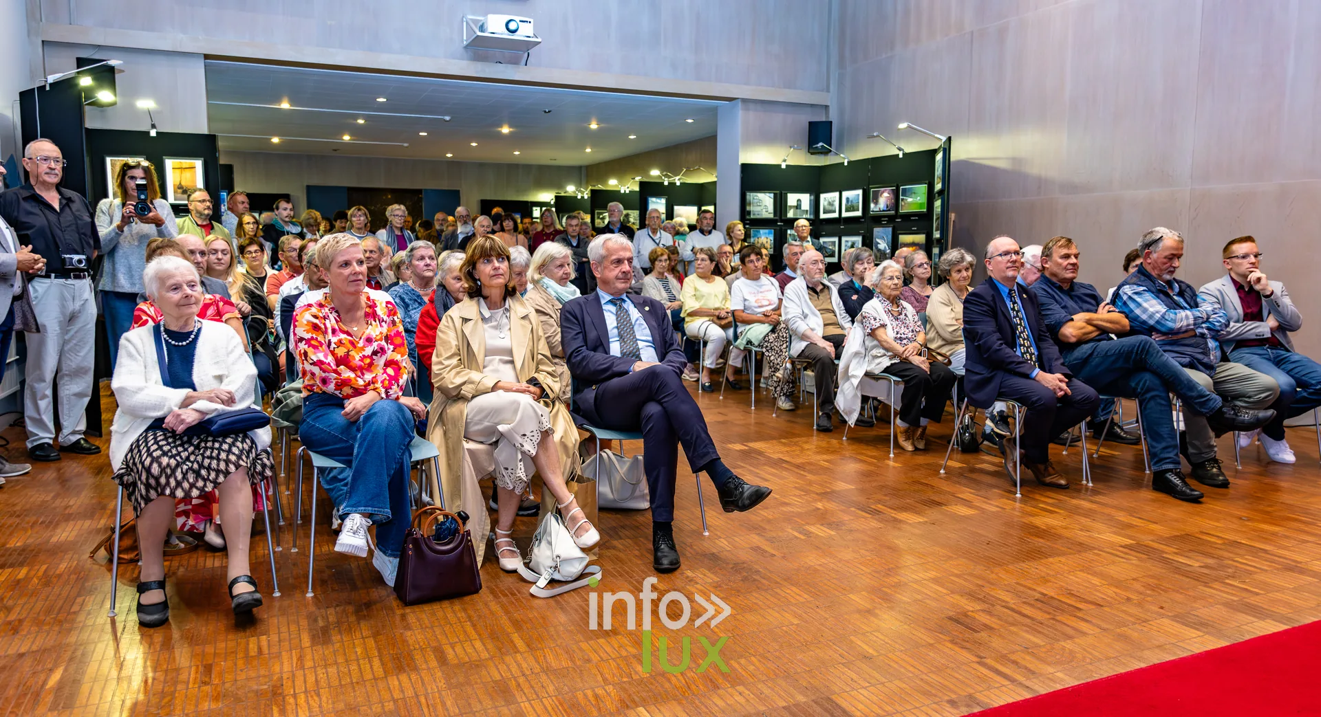 Public nombreux assis dans la salle des mariages de l’Hôtel de Ville de Nivelles lors du vernissage du Royal Photo Club Entre Nous