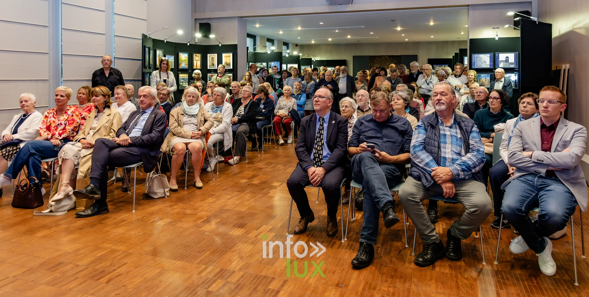 Public nombreux assis dans la salle des mariages de l’Hôtel de Ville de Nivelles lors du vernissage du Royal Photo Club Entre Nous