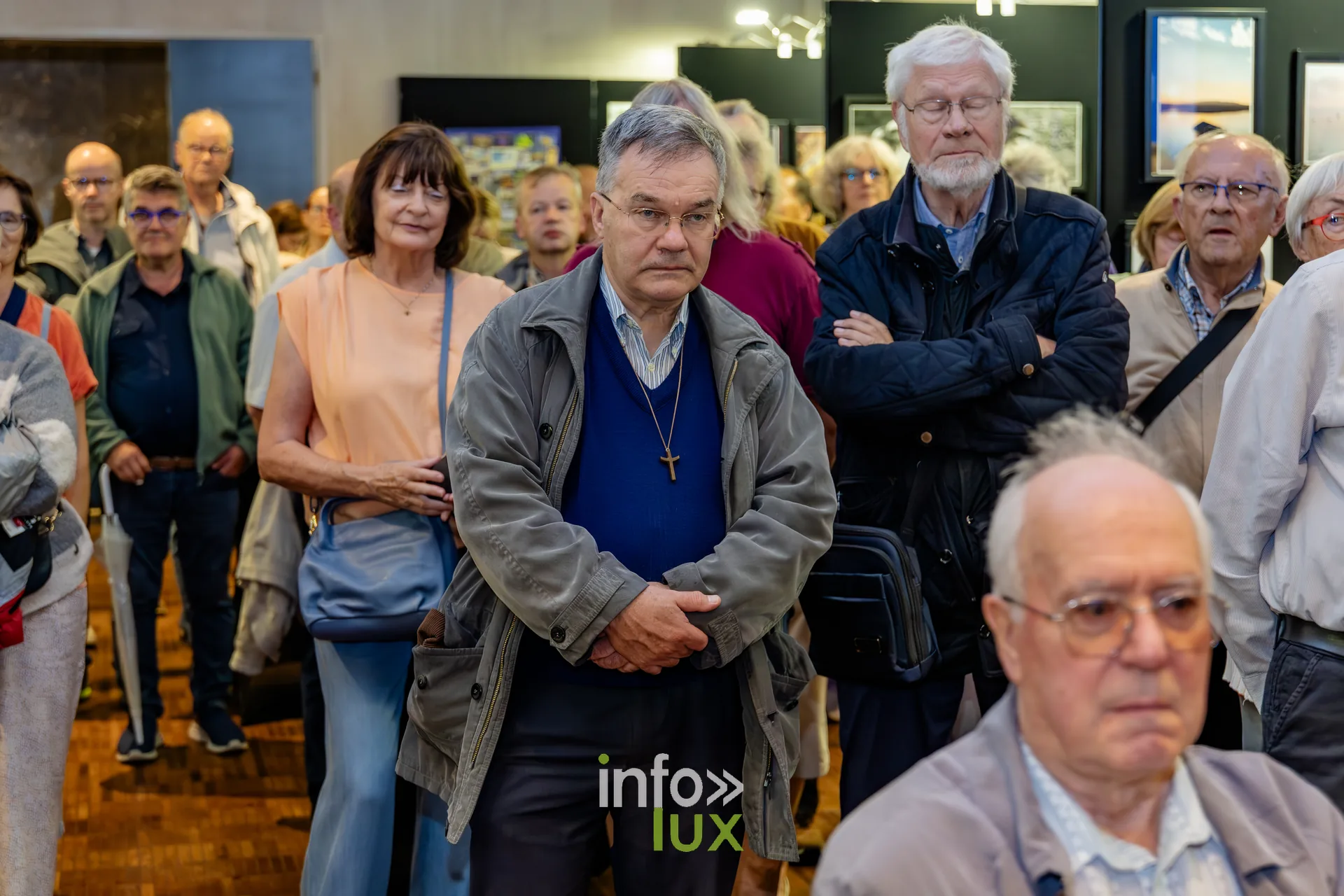Visiteurs debout au milieu des photographies exposées lors du vernissage du Royal Photo Club Entre Nous à Nivelles