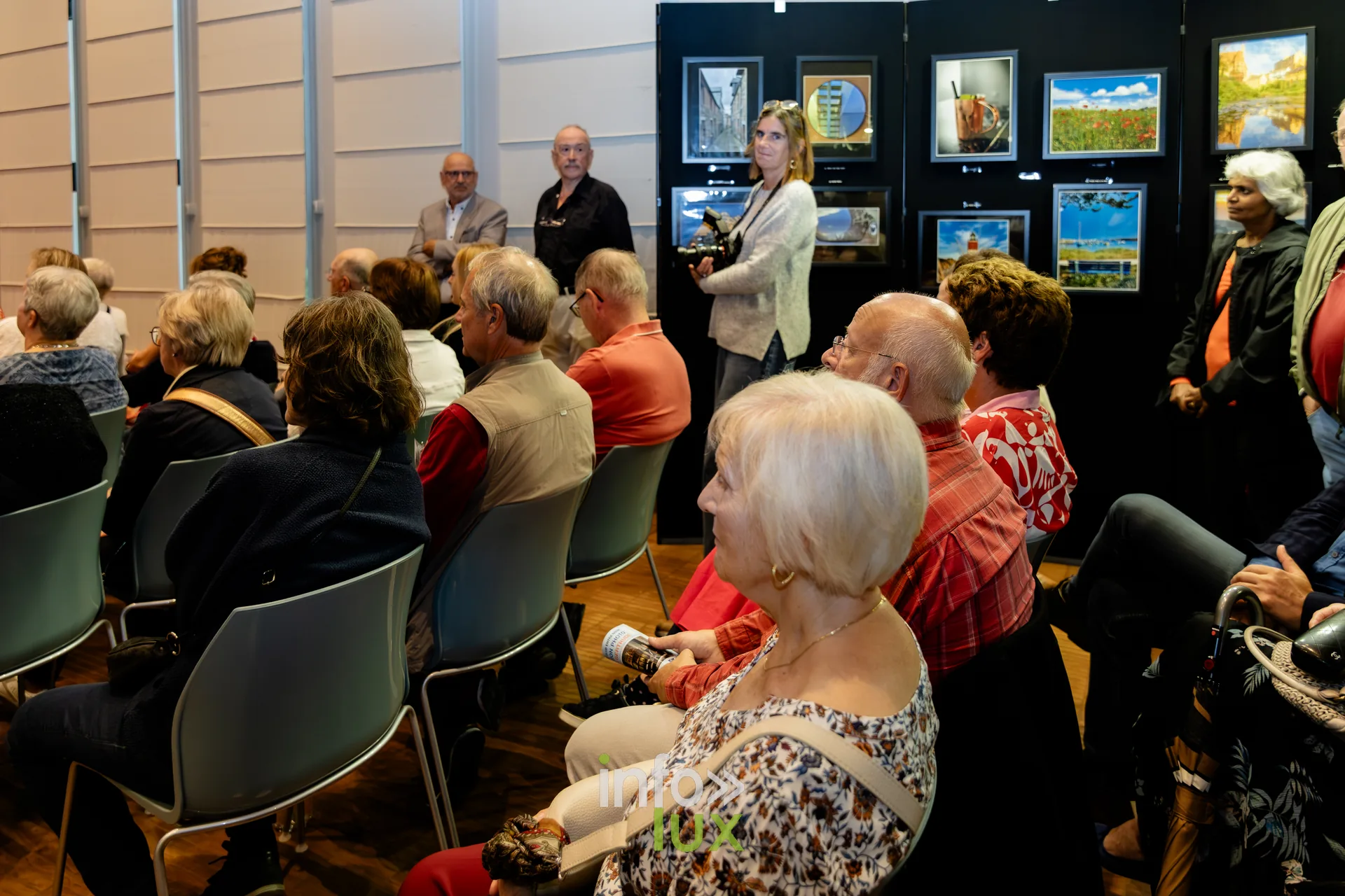 Public assis et debout au milieu des photographies exposées, vernissage du Royal Photo Club Entre Nous