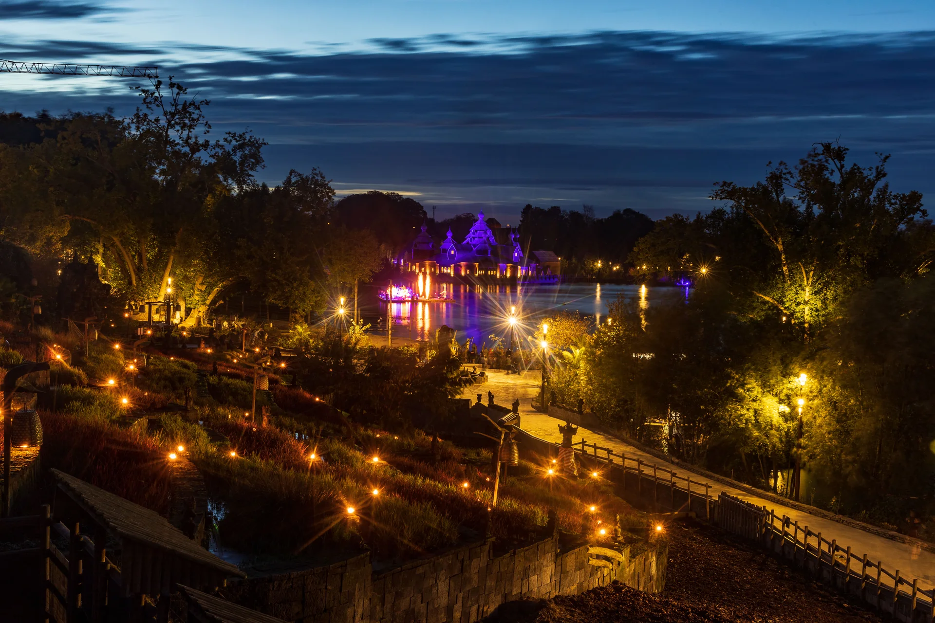 Le Jardin de Pairi Daiza illuminé à la tombée de la nuit, vue sur le lac depuis les rizières