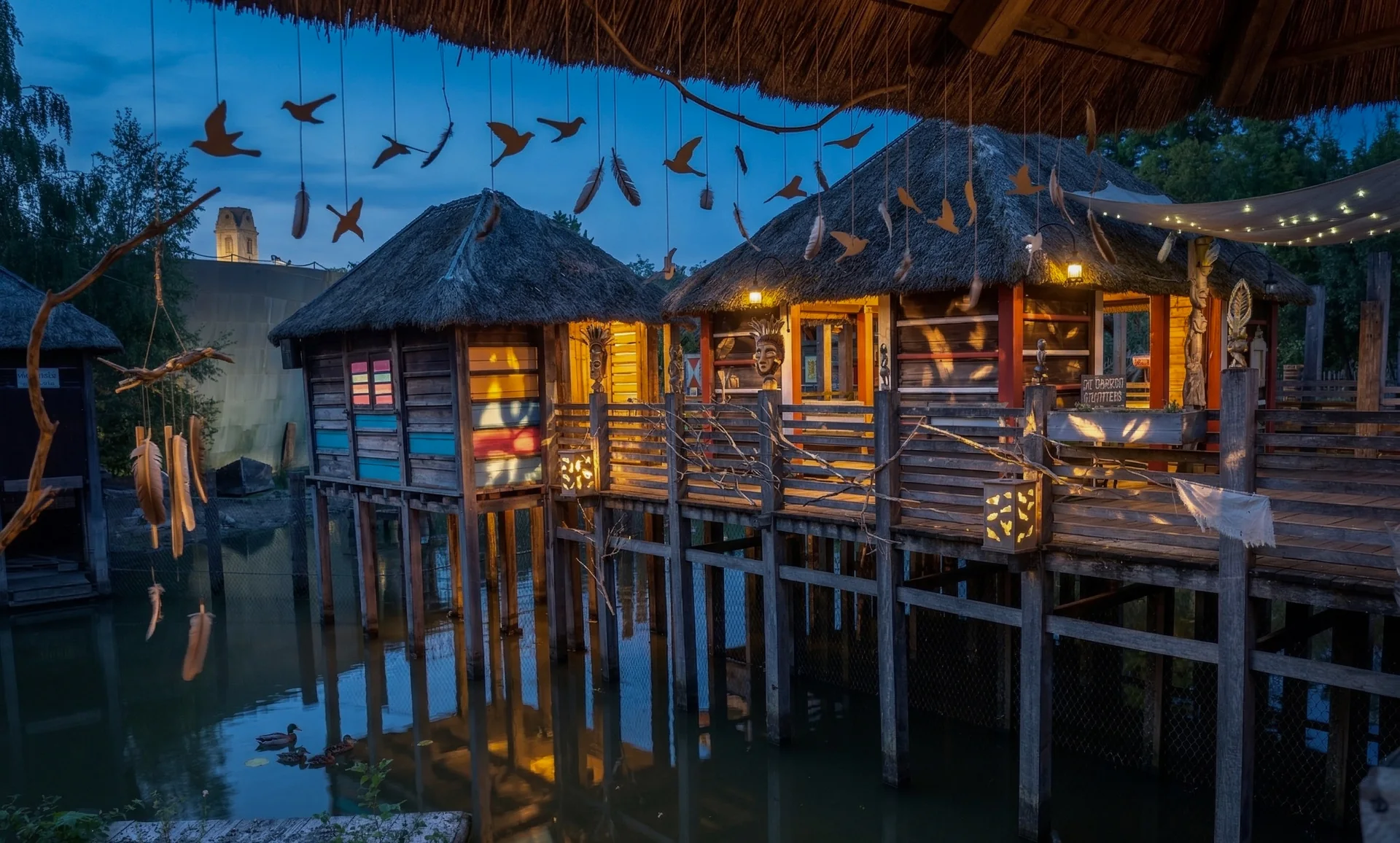 Village sur pilotis inspiré de Ganvié dans La Terre des Origines à Pairi Daiza, éclairé le soir