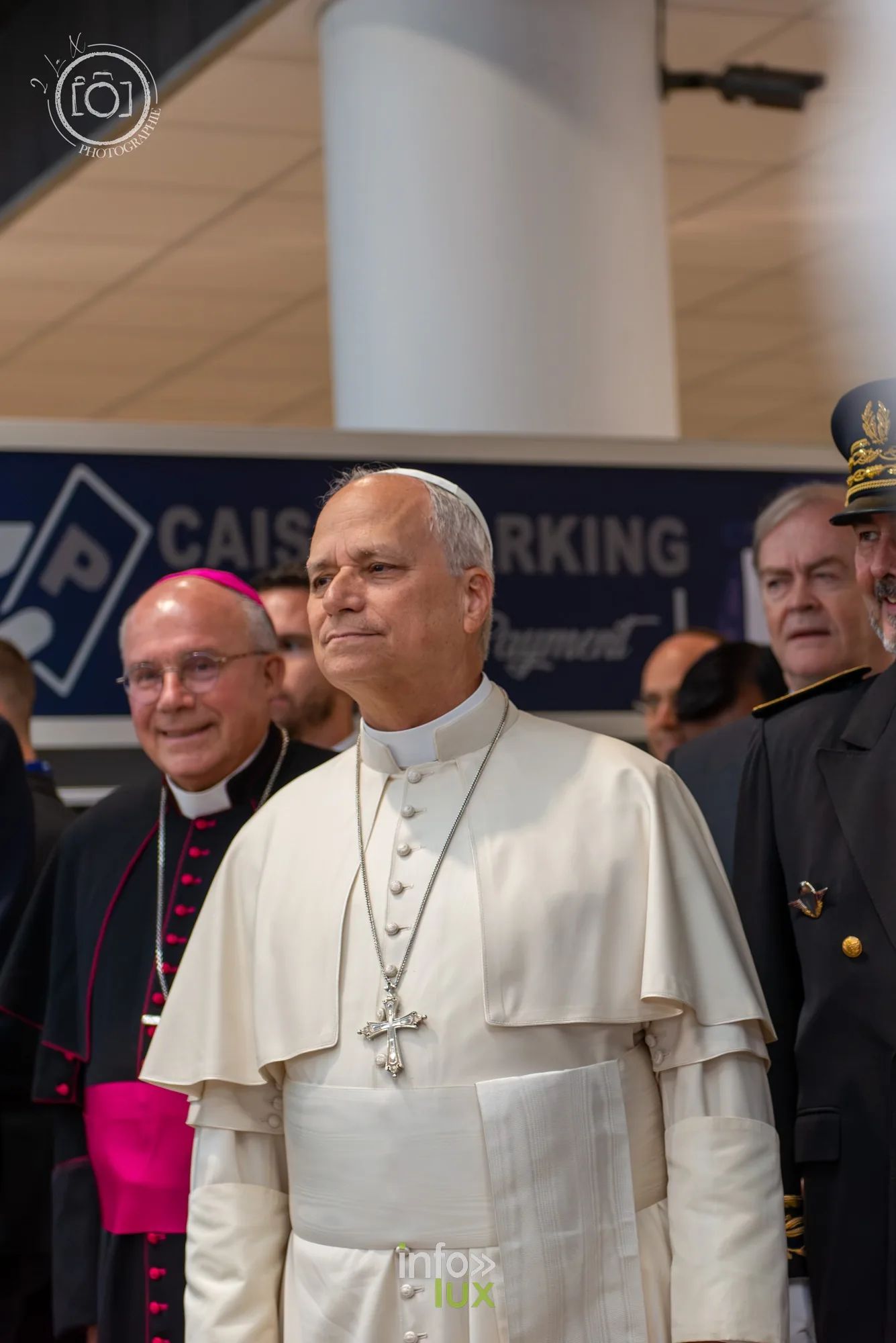 Le pape Léon XIV debout parmi les officiels, hall de l’aéroport de Metz, portrait vertical