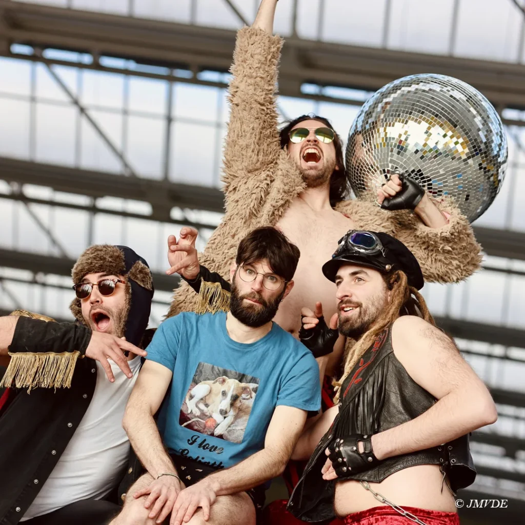 Les quatre air guitaristes de Party Crashers en costumes rock, boule à facettes et lunettes, visuel de The Cradle of Panthera