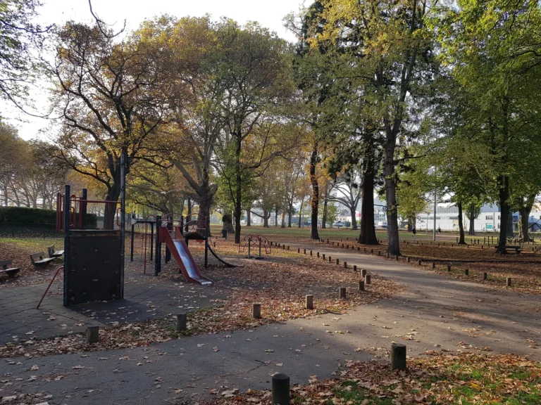 Plaine de jeux du parc Reine Astrid à Liège, toboggan et jeux sous les arbres en automne